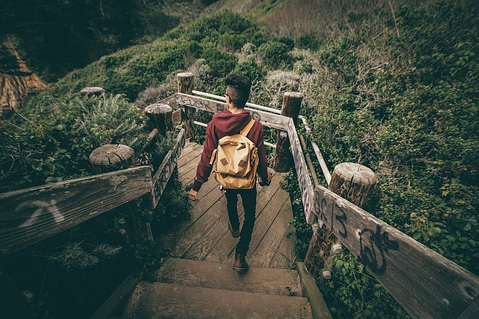 Азиатский юноша спускается по лестнице в парке